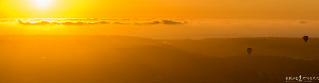 Looking west at the setting sun and balloons in Rancho Santa Fe from the top of Blacks Mountain.